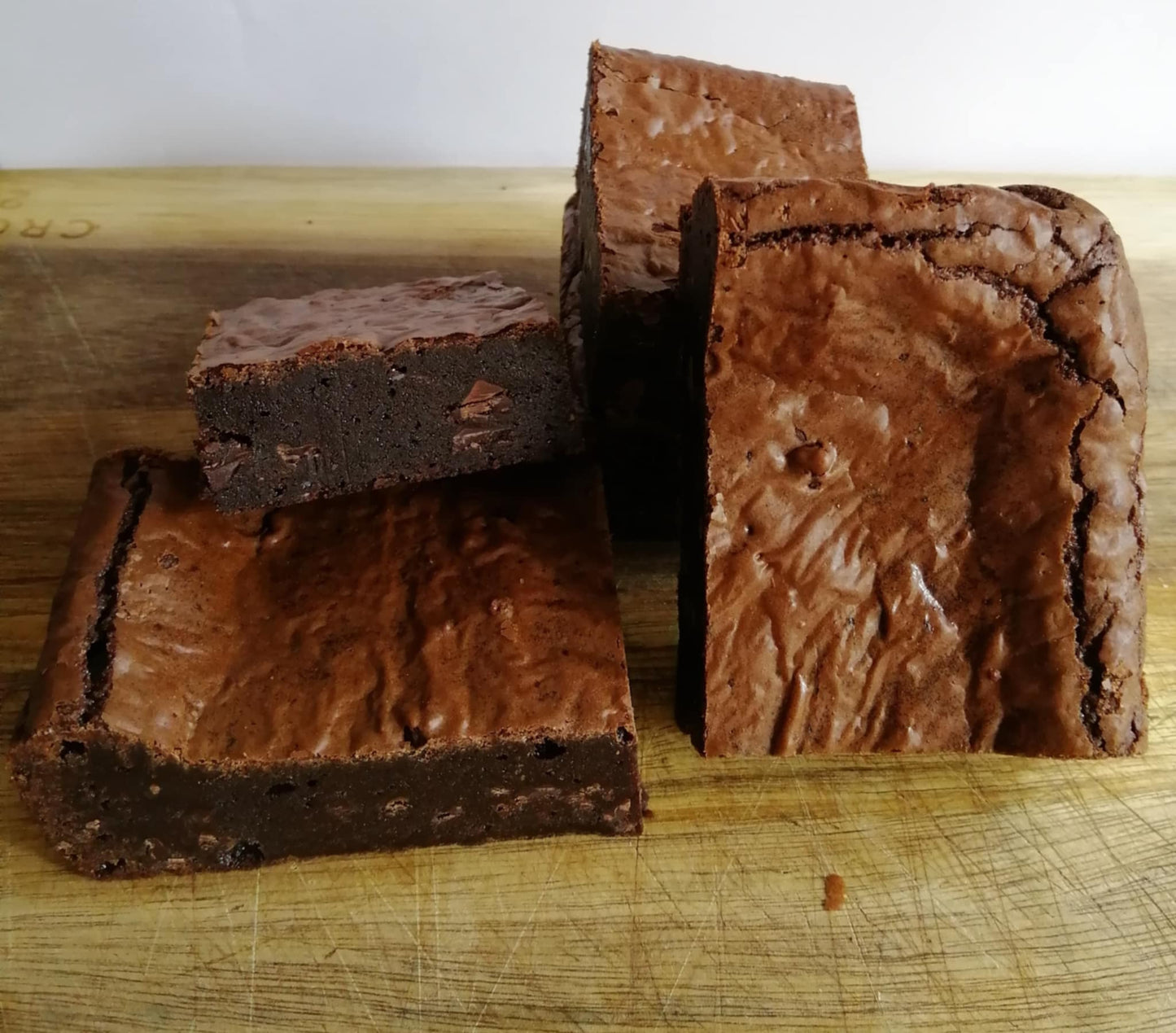 Gooey chocolate brownies on a wooden cutting board